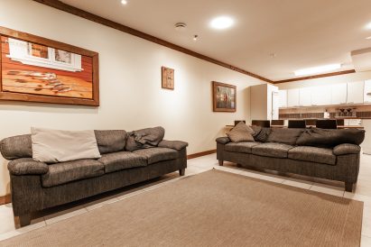 The living room on the lower floor of Evo Grand Villa. In the background, you can see the spacious combined kitchen and living room of the lower floor.