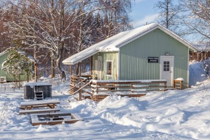 In front of Aulanko Lakeside's lakefront sauna, there is a wilderness-style fireplace and a wood-heated hot tub.