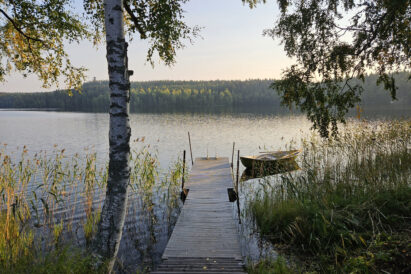 The pier at Aulangon Rantapiilo offers a stunning view of Lake Aulangonjärvi. On the opposite shore, the granite Aulanko observation tower can be seen in the distance.
