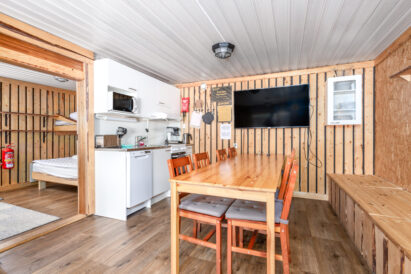 In the living room and kitchenette of Aulanko Lake Hide-out, there is space at the table for dining or a meeting for 8-9 people.