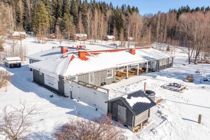 The front yard of Aulanko Grand Villa. In the foreground, a woodshed and a wood-fired hot tub.