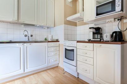 The kitchen of Evo Lakeside Villa is equipped with a stove/oven, coffee and water kettle, refrigerator, and microwave.