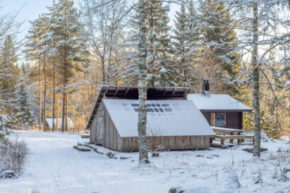 The outdoor lean-to at Tavastia Privacy has a fireplace, with smoke escaping through an opening at the ridge of the roof.