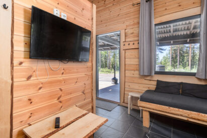 The living room of the Mini Villa in Loppi Wilderness Villa features its own flat-screen TV, making the space versatile for use as a group work area during meetings or as a viewing spot for sports matches with friends.