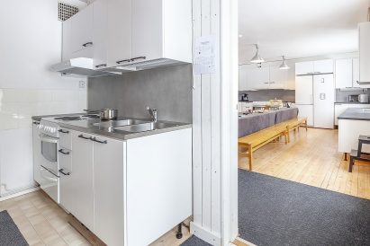 In Räyskälä Grand Villa, there are three kitchens. In the foreground, there is a mini-kitchen, and in the background, there is a spacious living kitchen.