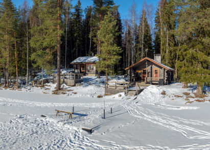 The lakeside sauna and main building of Evo Syväjärvi in the spring-winter sun.